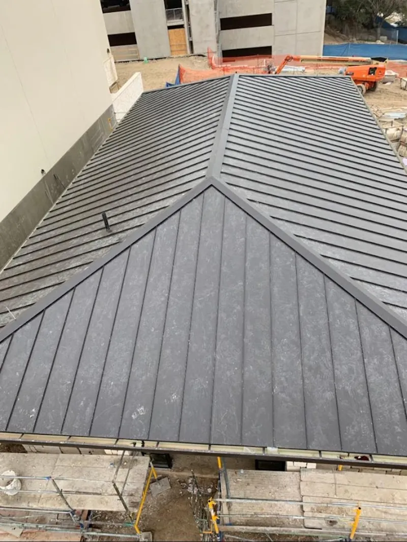 Commercial metal roof construction with crane equipment in Westfield